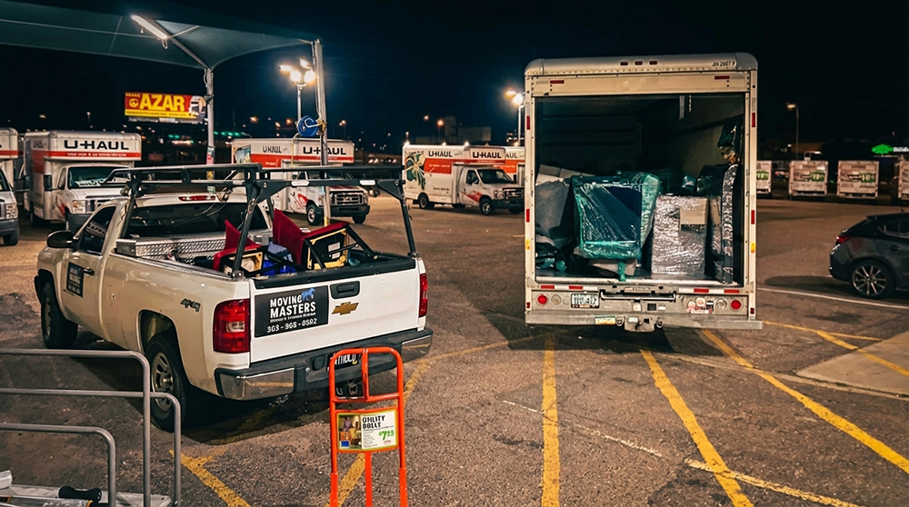 Denver Moving Mustangs trucks and gear at a night loading lot